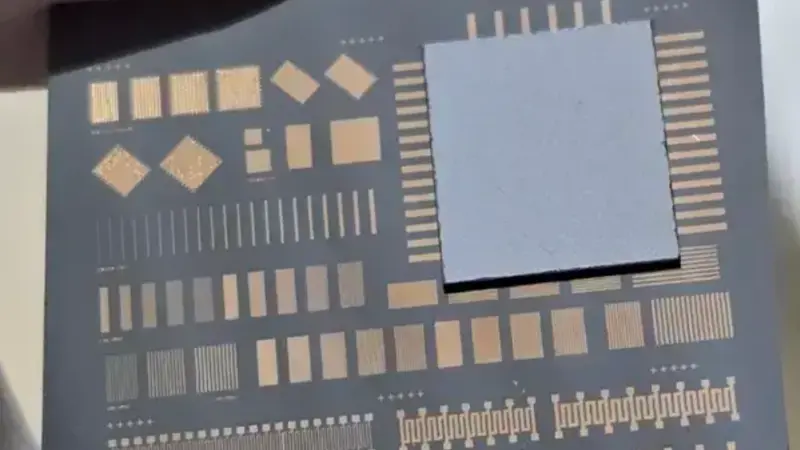 A bonded wafer showing a test pattern on a dark surface with a gray square overlay.